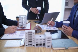 group of businessmen and investors discuss investing in real estate and jointly plan investments in construction projects of condominiums